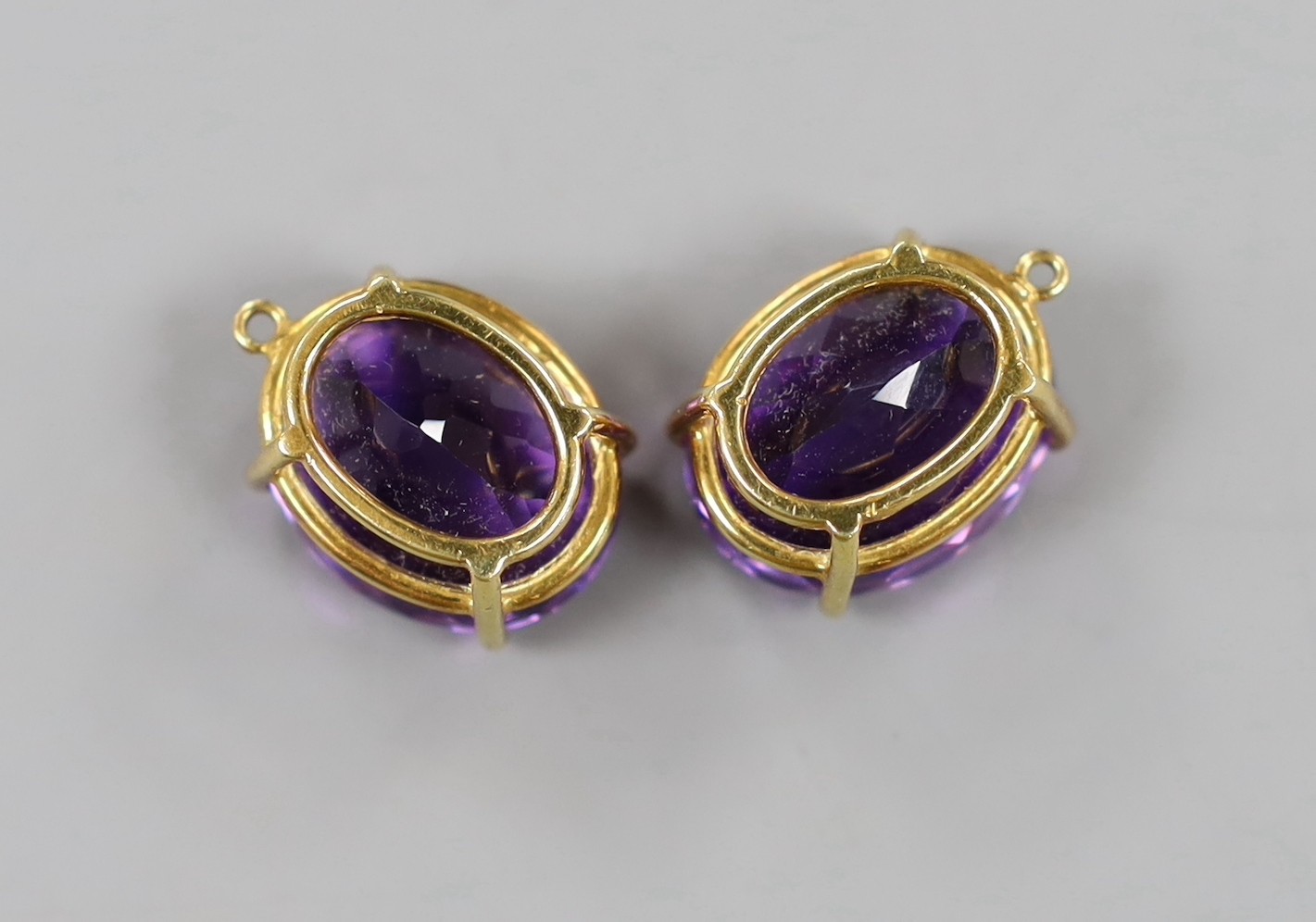 A modern pair of yellow metal mounted oval cut amethyst pendants?, 21mm, gross weight 13.8 grams.